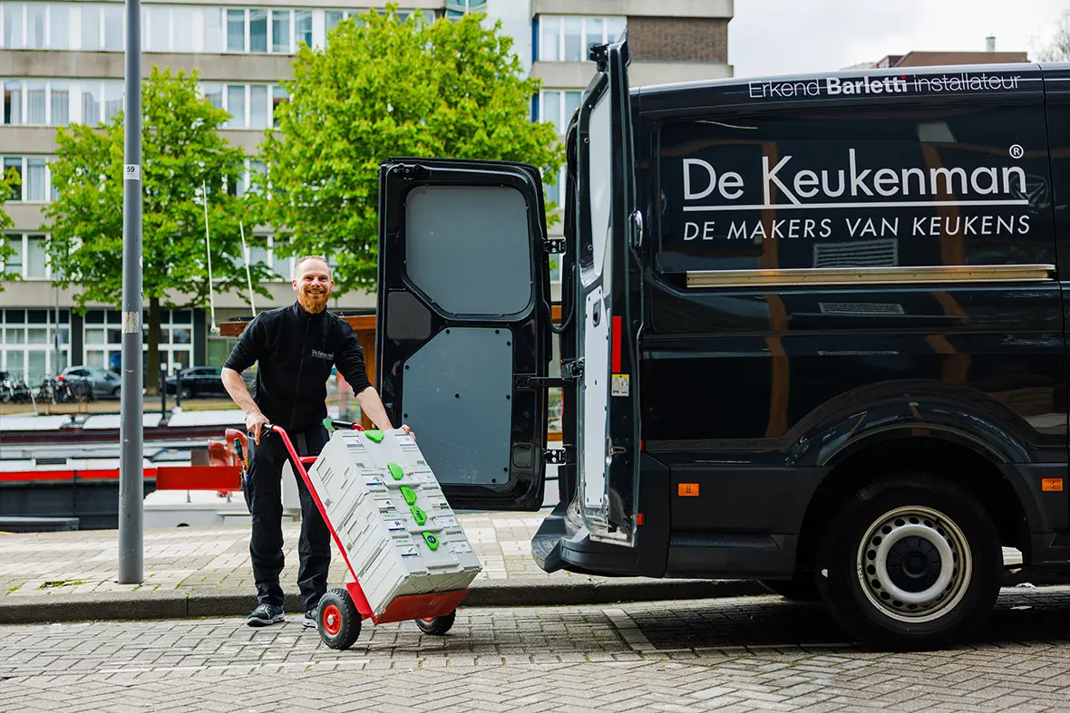 Vrouw met glimlach en mobiel in haar hand in een winkel.